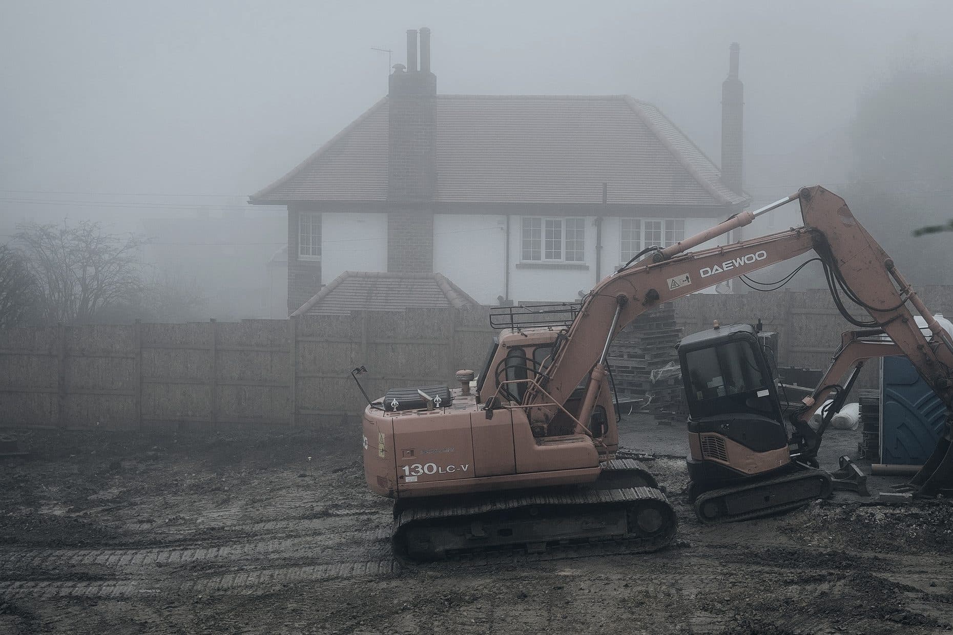 A dump truck comes down a quarry track, in the dust